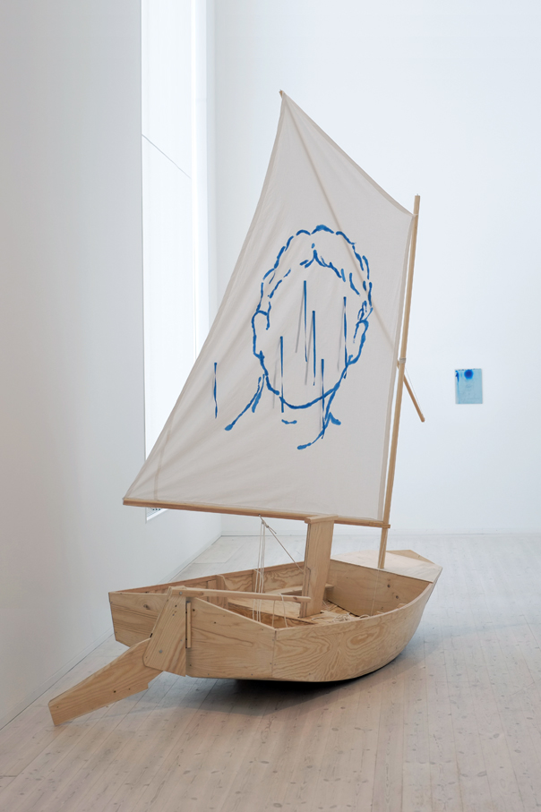 A small wooden boat with a drawing of a face on the sail